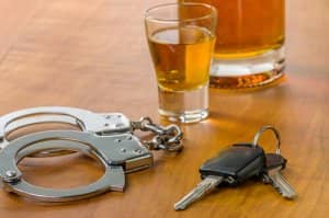 Image of a drink, car keys and handcuffs, indicating if you drink and drive you will get arrested.